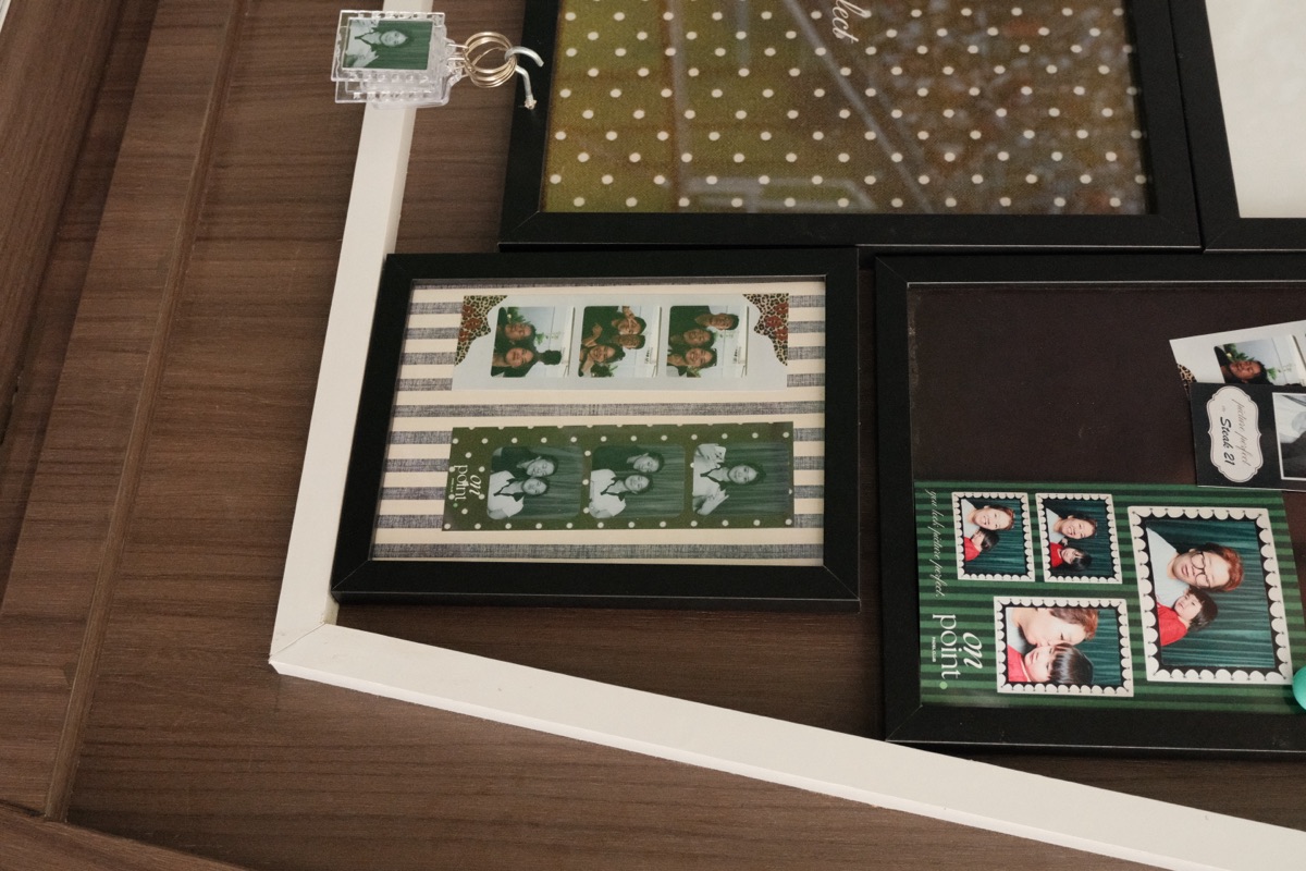 A wall of framed guest photo strips at On Point Padel